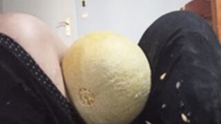 Woman crushes several fruits betwen her thighs