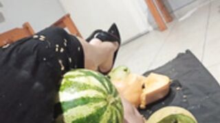 Woman crushes several fruits betwen her thighs