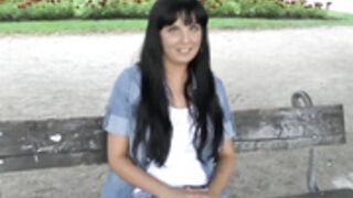 Brunette undresses in the midst of people