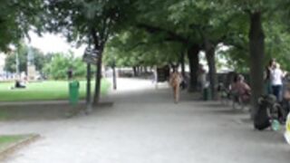 Brunette undresses in the midst of people