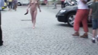 young woman with big breasts walks naked among the peop