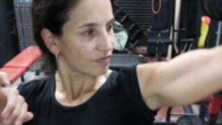 Fitness Latina flexing biceps and armpits sweaty