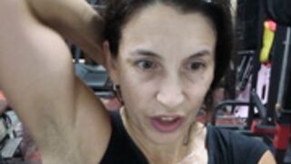 Fitness Latina flexing biceps and armpits sweaty